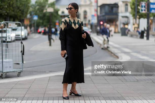 Guest wearing a knit and black dress, earings outside Rodebjer on August 30, 2017 in Stockholm, Sweden.