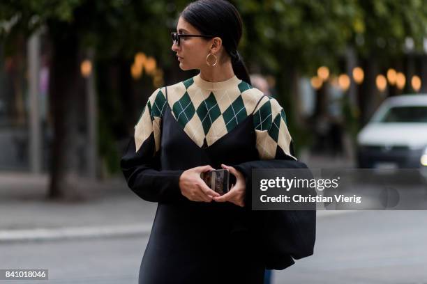 Guest wearing a knit and black dress, earings outside Rodebjer on August 30, 2017 in Stockholm, Sweden.