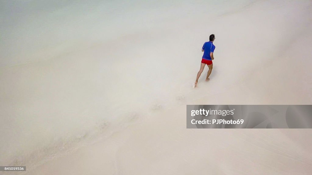 Vista aerea dell'uomo che corre sulla spiaggia tropicale alle Seychelles