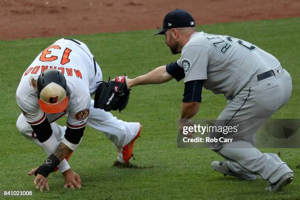 Marc Rzepczynski of the Seattle Mariners tags out Manny Machado of the Baltimore Orioles trying to reach home for the third out of the eighth inning...