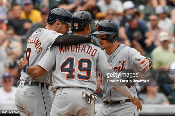 James McCann of the Detroit Tigers celebrates at home plate with Dixon Machado and Nicholas Castellanos after hitting a fifth inning three run...
