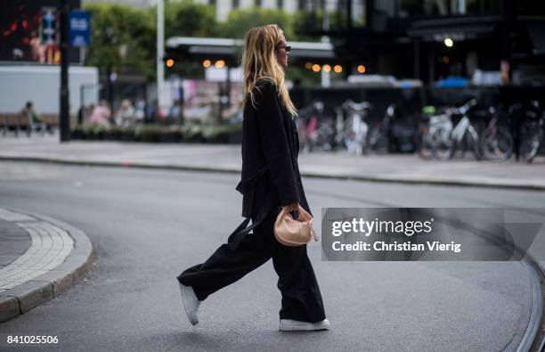 Blanca Miro Scrimieri wearing black coat and wide leg pants outside Rodebjer on August 30, 2017 in Stockholm, Sweden.