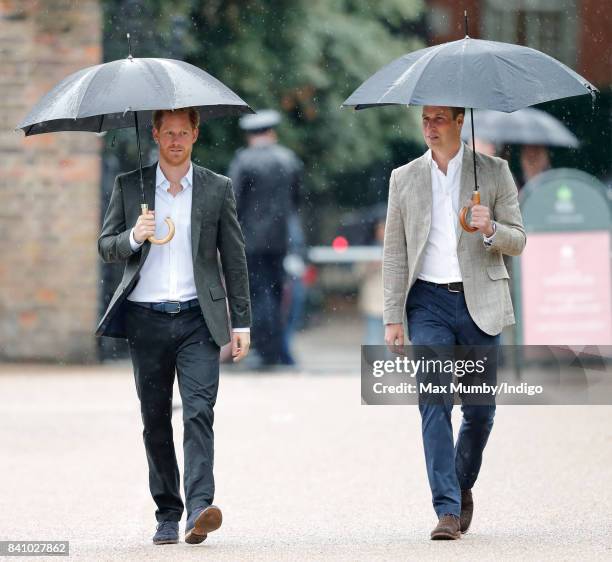 Prince Harry and Prince William, Duke of Cambridge arrive to view tributes to Diana, Princess of Wales left at the gates of Kensington Palace after...