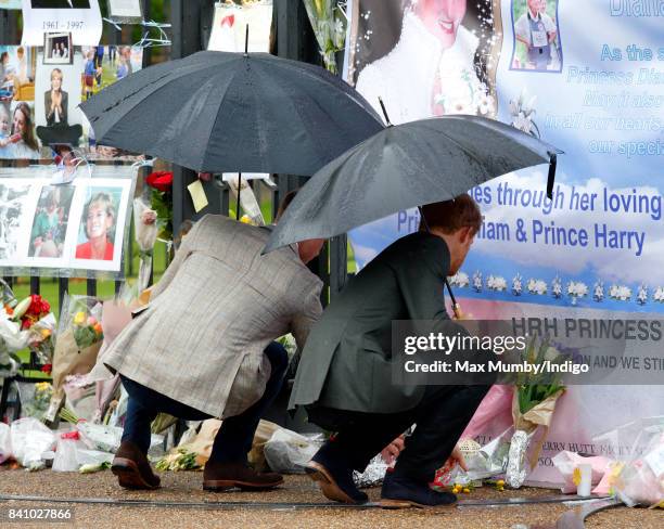 Prince William, Duke of Cambridge and Prince Harry view tributes to Diana, Princess of Wales left at the gates of Kensington Palace after visiting...