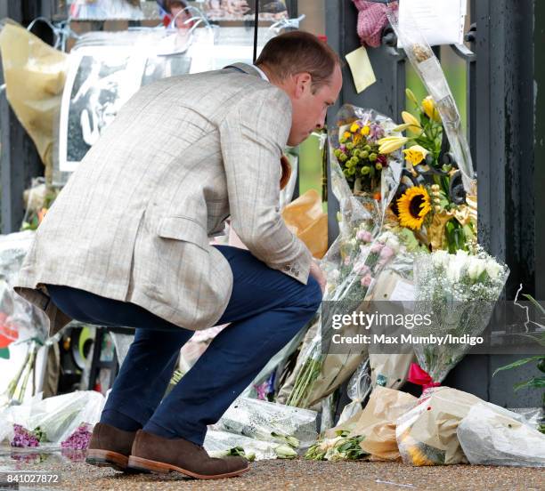 Prince William, Duke of Cambridge views tributes to Diana, Princess of Wales left at the gates of Kensington Palace after visiting the Sunken Garden...