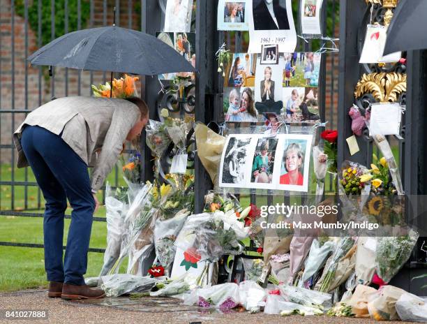 Prince William, Duke of Cambridge views tributes to Diana, Princess of Wales left at the gates of Kensington Palace after visiting the Sunken Garden...