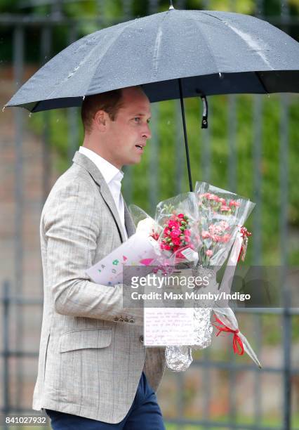 Prince William, Duke of Cambridge receives flowers from members of the public to place at the gates of Kensington Palace in tribute to Diana,...