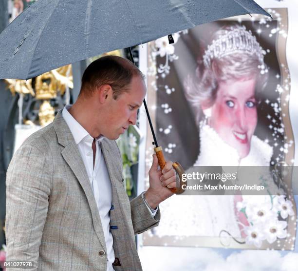 Prince William, Duke of Cambridge views tributes to Diana, Princess of Wales left at the gates of Kensington Palace after visiting the Sunken Garden...