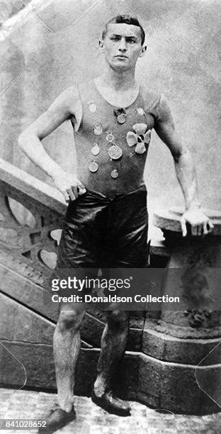 Ehrich Weiss, aka magician Harry Houdini, full-length portrait, standing, facing front, wearing track team medals, in New York.