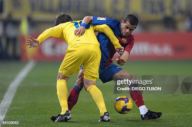 Villarreal's Cani fights for the ball with Barcelona 's Brazilian player Daniel Alves during their Spanish league football match at Madrigal Stadium...