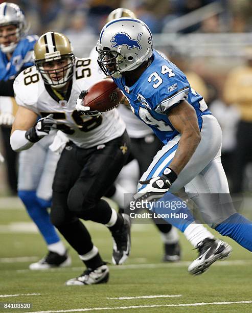 Running back Kevin Smith of the Detroit Lions runs for a first down as linebacker Scott Shanle of the New Orleans Saints gets ready to make the...