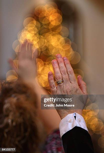 Worshippers raise their hands prayer during a service at the Wilmington Church of God December 21, 2008 in Wilmington, Ohio. The pastor, Elizabeth...