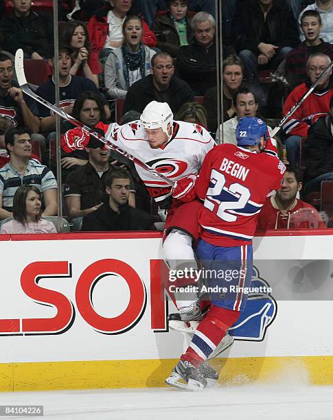 Steve Begin of the Montreal Canadiens bodychecks Joe Corvo of the Carolina Hurricanes into the glass at the Bell Centre on December 21, 2008 in...