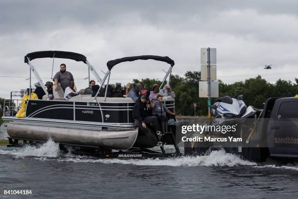 Locals hitch a ride on a boat getting towed through floodwater in the wake of tropical storm Harve in Port Arthur, Texas, on Aug. 30, 2017.