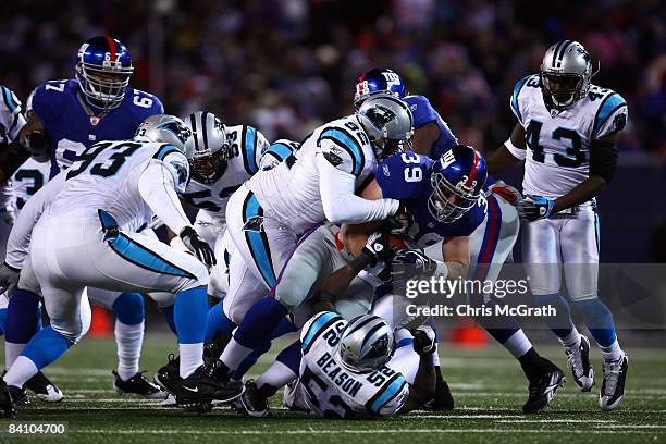 Full Back Madison Hedgecock of the New York Giants gets tackled by Damione Lewis of the Carolina Panthers on December 21, 2008 at Giants Stadium in...