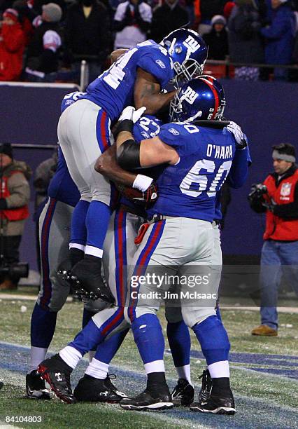 Running back Brandon Jacobs of the New York Giants celebrates with teammates Derrick Ward and Shaun O'Hara in the end zone after scoring a touchdown...