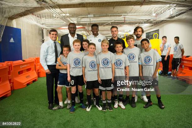 Jon Patricof, Patrick Vieira, Sean Johnson, R. J. Allen and Andrea Pirlo pose with the kids of the NYCFC Youth Program at the NYCFC pop-up experience...