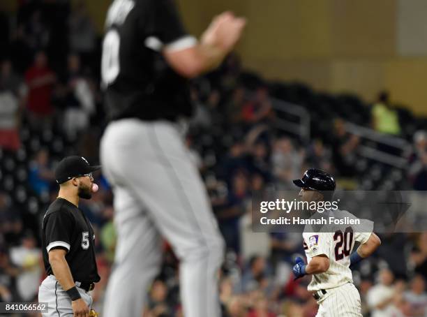 Yolmer Sanchez and Mike Pelfrey of the Chicago White Sox look on as Eddie Rosario of the Minnesota Twins rounds the bases after hitting a solo home...