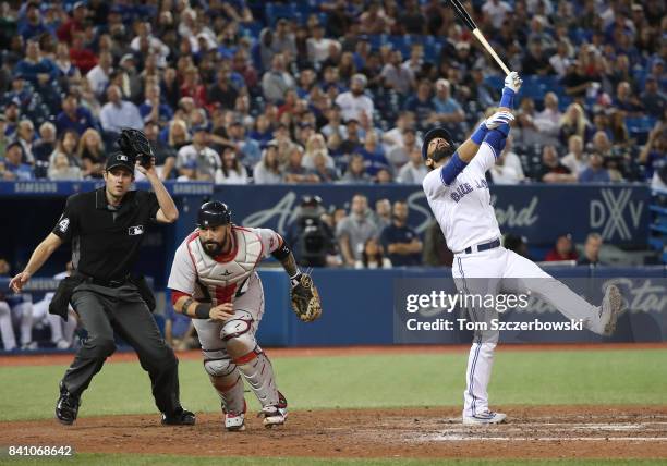 Jose Bautista of the Toronto Blue Jays reacts as he hits a foul pop up in the ninth inning during MLB game action as Sandy Leon of the Boston Red Sox...