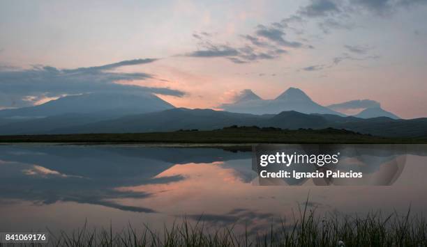 reflection on lake at sunrise, tolbachik volcanic complex, kamchatka - kamchatka volcano stock pictures, royalty-free photos & images