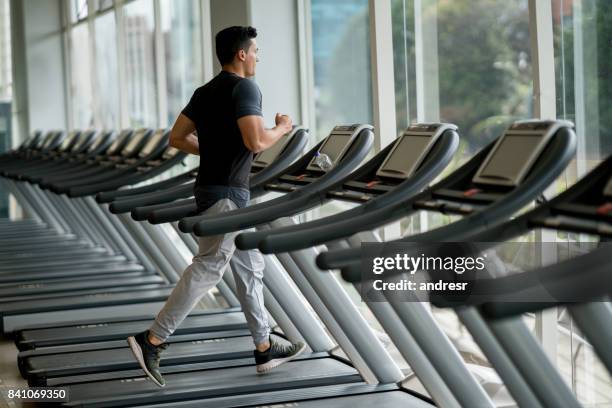 knappe man op de sportschool op een loopband - running on treadmill stockfoto's en -beelden