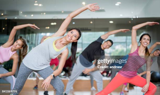 glückliche menschen in einem aerobic-kurs in der turnhalle - group exercise stock-fotos und bilder