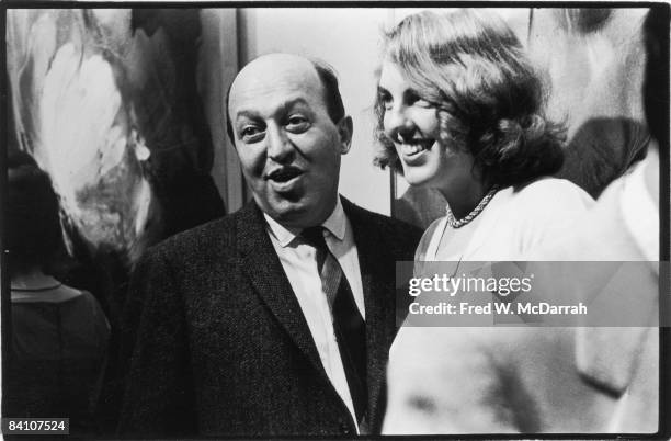 American art critic Clement Greenberg and his wife Janice van Horne Greenberg share a joke at an unidentified event, New York, New York, late 1950s...