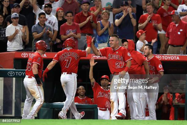 Kole Calhoun, Mike Trout and C.J. Cron congratulate Cliff Pennington of the Los Angeles Angels after his grandslam homerun during the seventh inning...