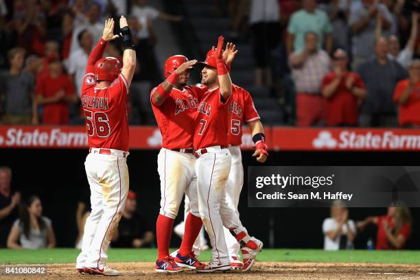 Kole Calhoun, Luis Valbuena and Albert Pujols congratulate Cliff Pennington of the Los Angeles Angels at homeplate after he hit a grandslam homerun...