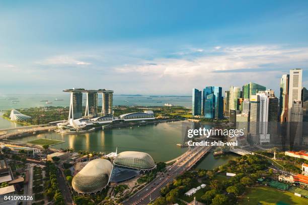 singapur: lancha cruzando marina bay. jardín y supertrees fviewed arboleda del parque de la marina oriental con flores en primer plano en la nube - merlion park fotografías e imágenes de stock