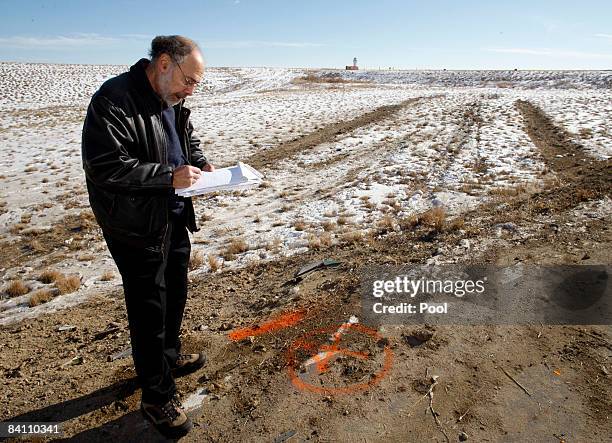 Reporter Jeffrey Leib takes notes as he surveys the skid marks left by a Continental Airlines jetliner December 22, 2008 in Denver, Colorado. The...