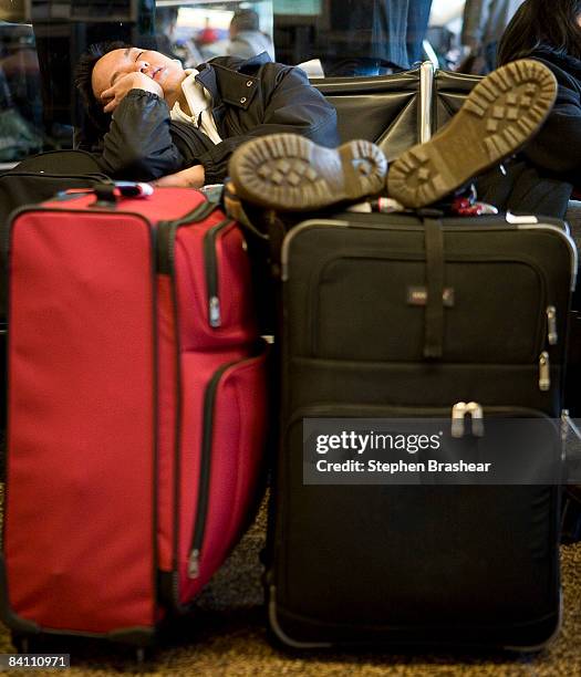 Jason Molina of Mill Creek, Washington sleeps while waiting a flight to San Francisco, California at the Seattle-Tacoma International Airport...