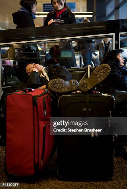 Jason Molina of Mill Creek, Washington sleeps while waiting a flight to San Francisco, California at the Seattle-Tacoma International Airport...