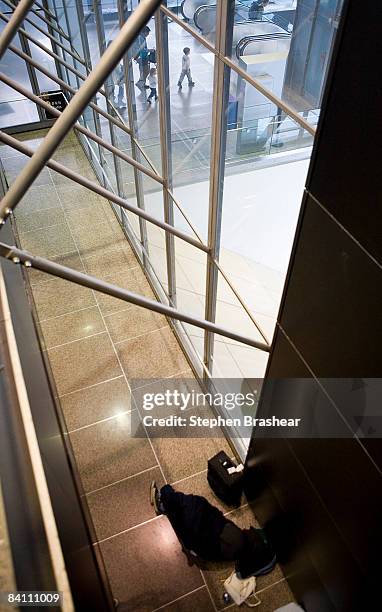 Traveler sleeps in an alcove at the Seattle-Tacoma International Airport December 22, 2008 in Seattle, Washington. Heavy snowfall in the area delayed...