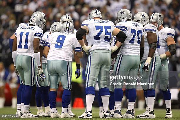 Quarterback Tony Romo of the Dallas Cowboys huddles together with his offense for the play call during their NFL game against the Baltimore Ravens at...