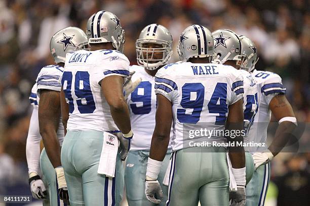 DeMarcus Ware of the Dallas Cowboys huddles together with his defensive line during their NFL game against the Baltimore Ravens at Texas Stadium on...