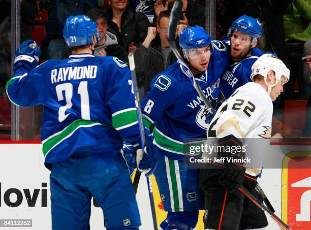 Ryan Kesler of the Vancouver Canucks is congratulated by teammates Steve Bernier and Mason Raymond after scoring against the Anaheim Ducks during...