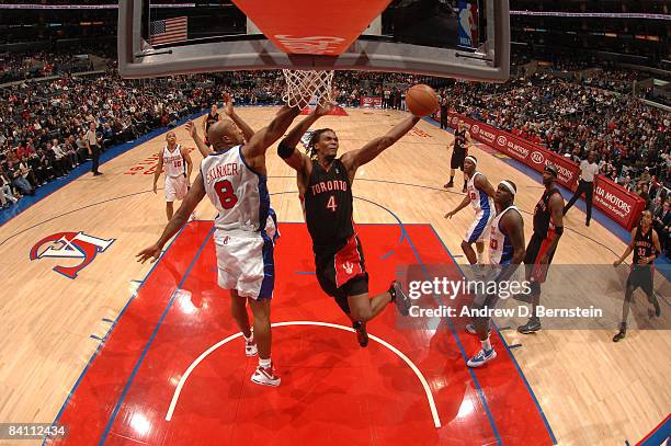 Chris Bosh of the Toronto Raptors avoids contact from Brian Skinner of the Los Angeles Clippers while attempting a shot during their game at Staples...