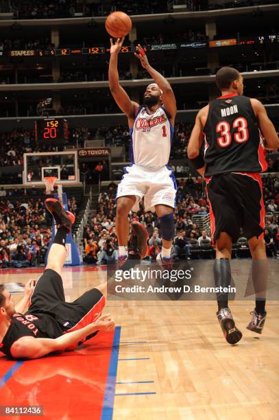 Baron Davis of the Los Angeles Clippers shoots while Jose Calderon of the Toronto Raptors falls to the floor during their game at Staples Center on...