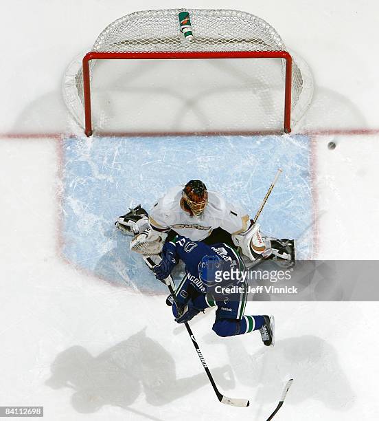 Daniel Sedin of the Vancouver Canucks deflects the puck in front of Jonas Hiller of the Anaheim Ducks during their game at General Motors Place on...
