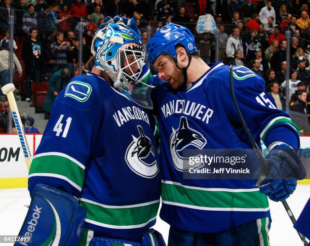 Curtis Sanford of the Vancouver Canucks is congratulated by teammate Mike Brown during their game against the Anaheim Ducks at General Motors Place...