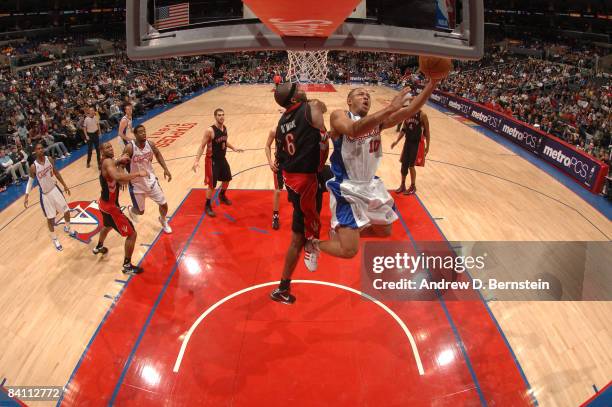 Eric Gordon of the Los Angeles Clippers puts up a shot against the defense of Jermaine O'Neal of the Toronto Raptors at Staples Center on December...