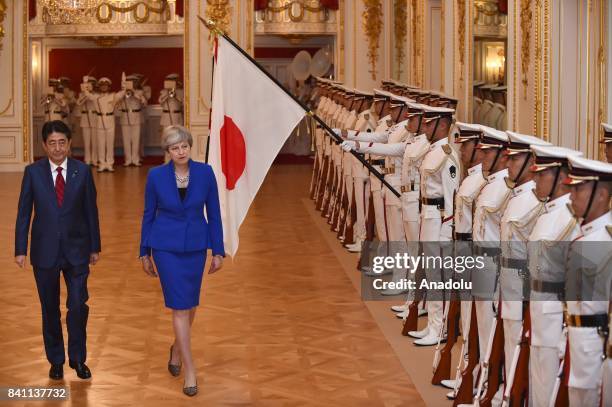 British Prime Minister Theresa May reviews the guard of honour with Japanese Prime Minister Shinzo Abe during a welcoming ceremony at the Akasaka...