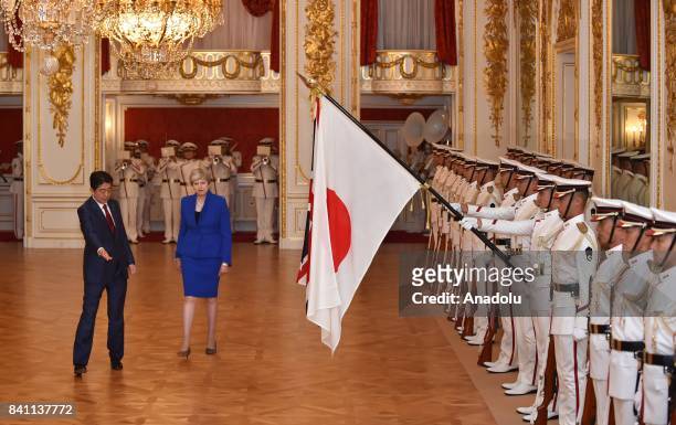 British Prime Minister Theresa May reviews the guard of honour with Japanese Prime Minister Shinzo Abe during a welcoming ceremony at the Akasaka...