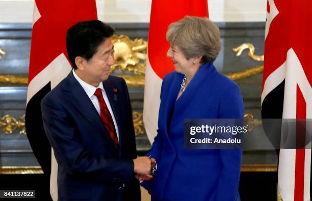 British Prime Minister Theresa May shakes hands with her Japanese counterpart Shinzo Abe prior to a meeting at the Akasaka Palace State Guest House...