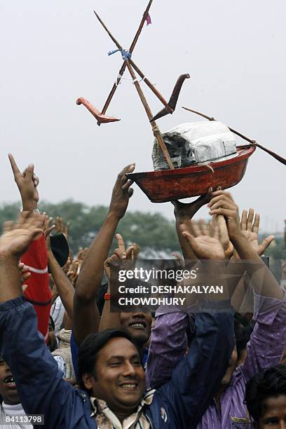 Supporters of Bangladesh's Awami League party hold a boat during an election campaign rally in Narayanganj, some 20 Kms from Dhaka, on December 23,...