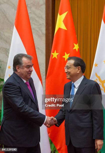 Chinese Premier Li Keqiang and Tajikistan's President Emomali Rahmon shake hands during their meeting at the Great Hall of the People in Beijing,...