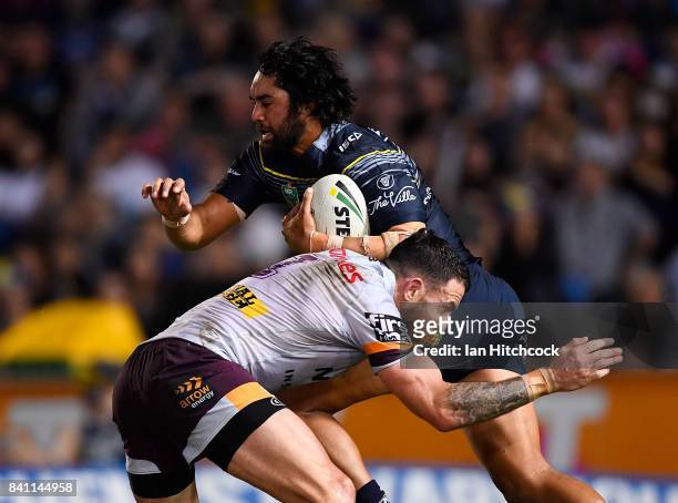 Javid Bowen of the Cowboys is tackled by Darius Boyd of the Broncos during the round 26 NRL match between the North Queensland Cowboys and the...