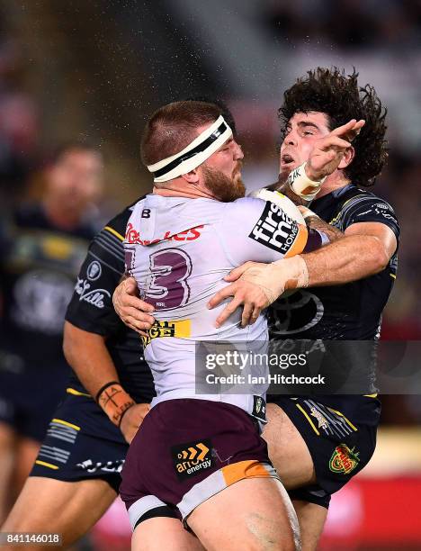 Josh McGuire of the Broncos is tackled by Jake Granville of the Cowboys during the round 26 NRL match between the North Queensland Cowboys and the...