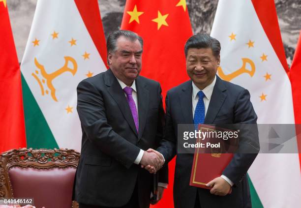 Chinese President Xi Jinping with Tajikistan's President Emomali Rahmon shake hands during the signing ceremony at the Great Hall of the People in...